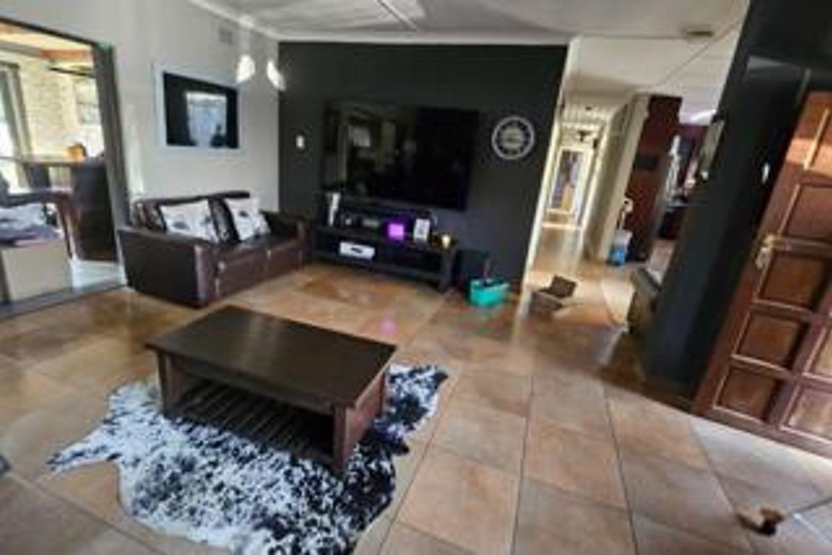 A spacious living room featuring tiled flooring and a dark accent wall, providing a comfortable area for relaxation and entertainment.