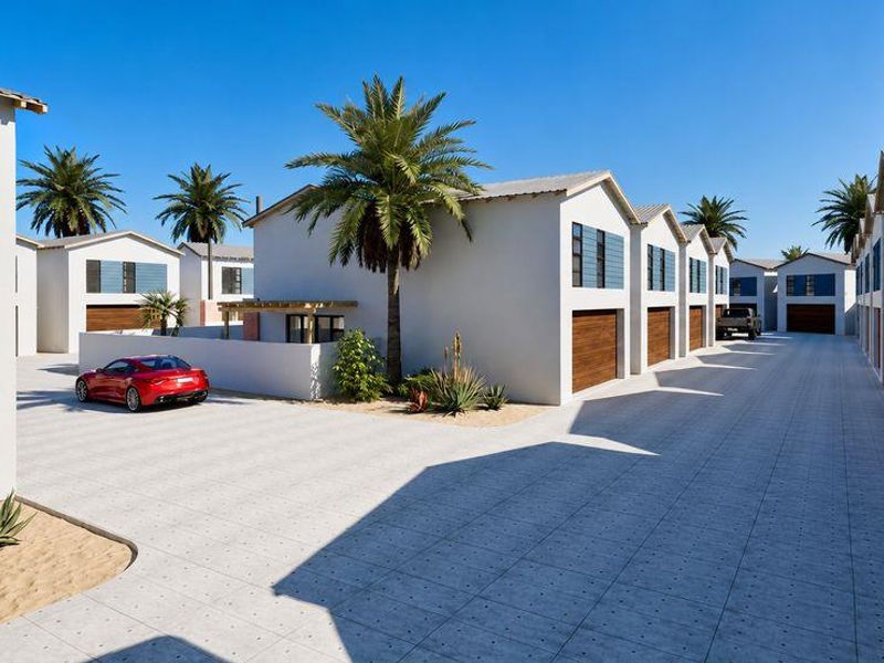 A modern townhouse complex featuring paved driveways, multiple garage access points, and clean architectural lines in a well-maintained residential setting.