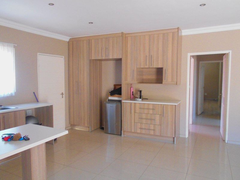 A functional kitchen featuring light wood-finish cabinetry, tiled flooring, and ample storage space, providing a clean and neutral foundation for modern updates.