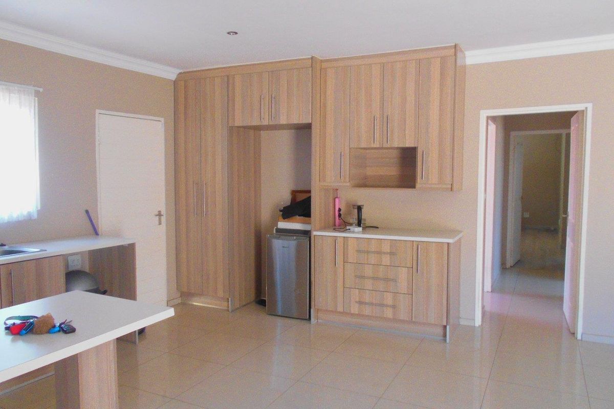 A functional kitchen featuring light wood-finish cabinetry, tiled flooring, and ample storage space, providing a clean and neutral foundation for modern updates.