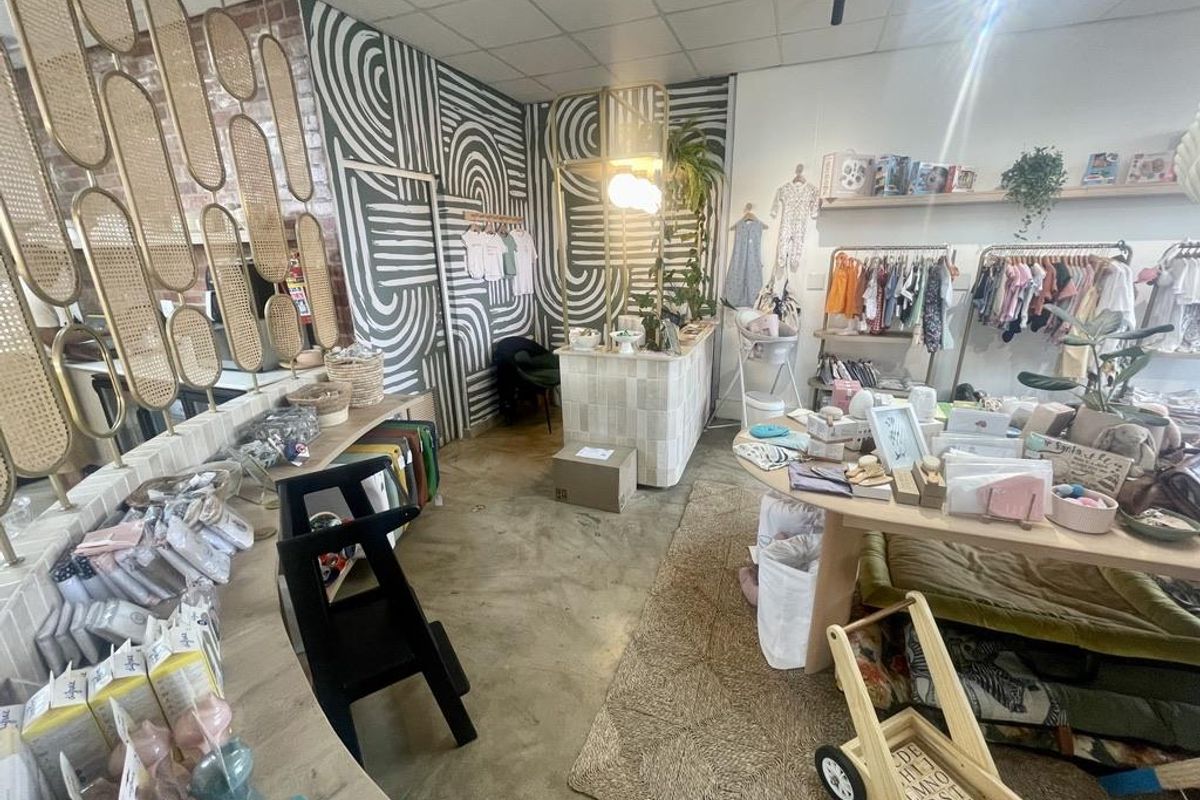 A retail space featuring a polished concrete floor, exposed brick accents, a tiled service counter, and a suspended ceiling.