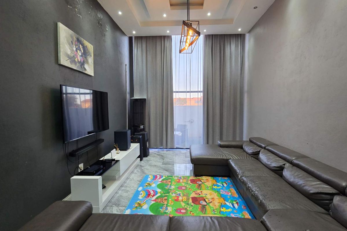 Modern living room featuring high ceilings, recessed lighting, and large windows with full-height curtains, finished with marble-look floor tiles.