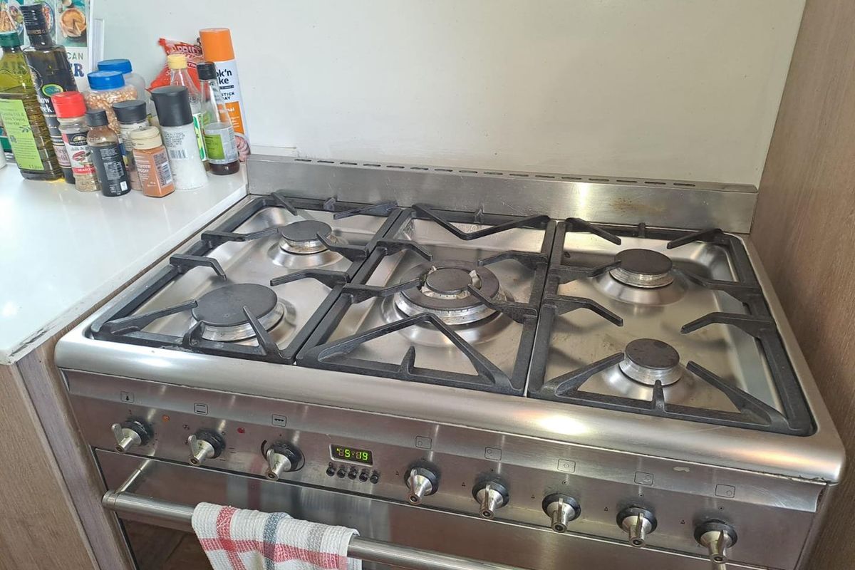 A stainless steel gas stove and oven unit integrated into the kitchen cabinetry.