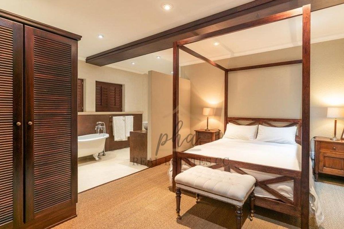 Spacious bedroom featuring an open-plan en-suite bathroom with a freestanding bathtub and integrated cabinetry.