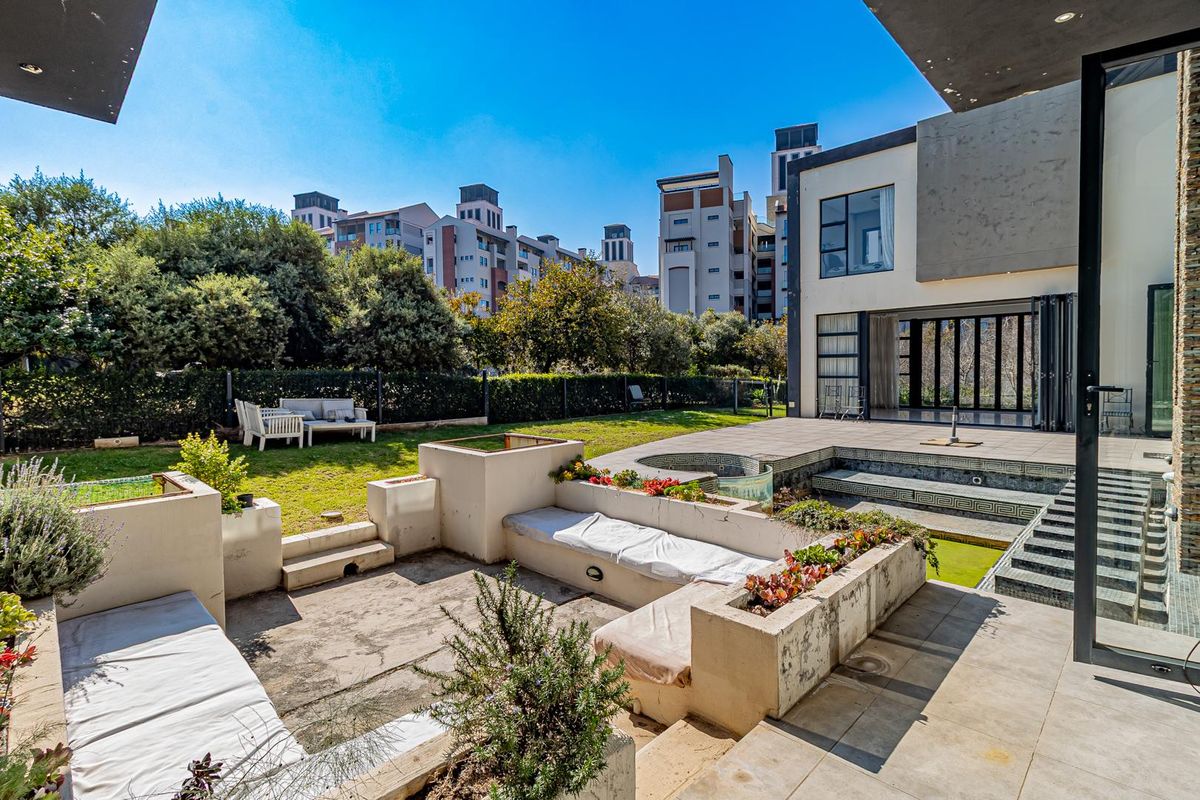 Outdoor entertainment area featuring a sunken seating space, built-in planters, and a swimming pool adjacent to the rear patio and garden.