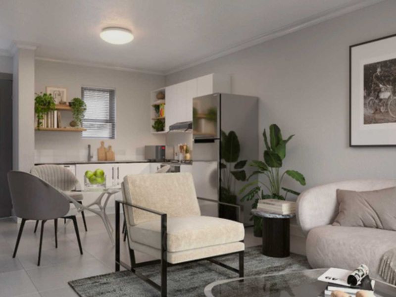 Modern open-plan living area featuring a compact kitchen with built-in cabinetry and tiled flooring, seamlessly integrated with the lounge space.