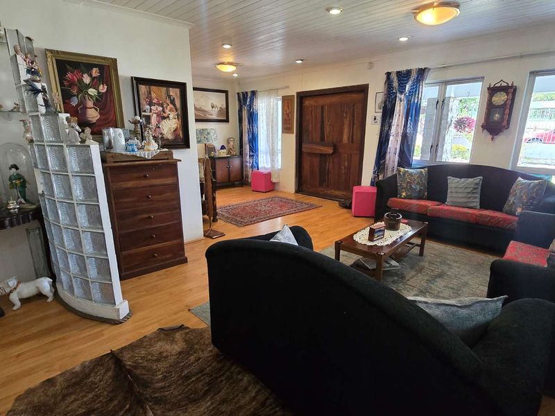Spacious living area featuring timber flooring, recessed lighting, and a decorative glass block partition, providing a functional layout with natural light.