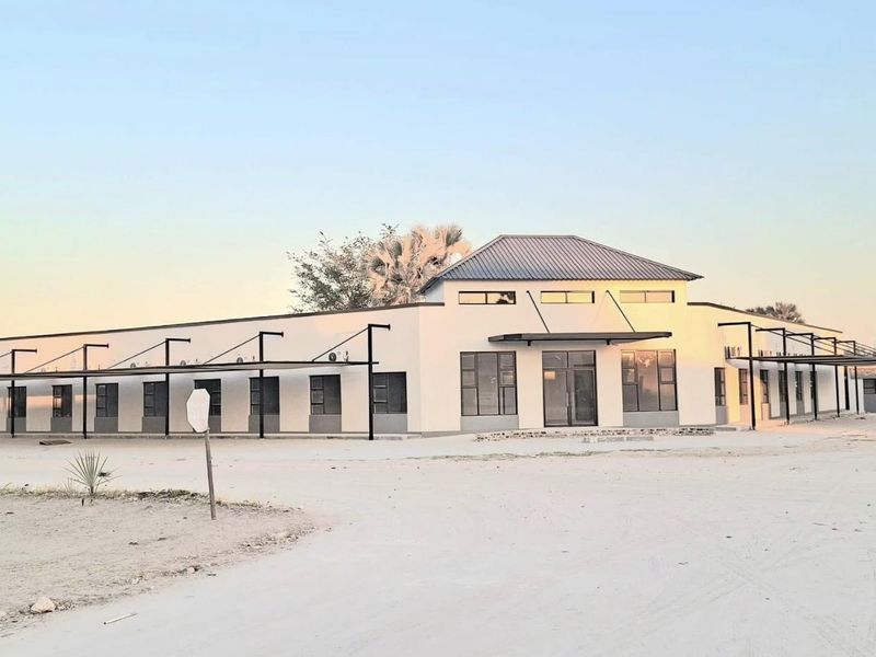 Modern single-story office building featuring a clean facade, metal roofing, and extensive aluminum-framed windows with covered exterior walkways.