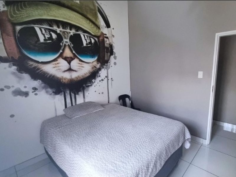 A bedroom featuring tiled flooring and a large decorative wall mural.