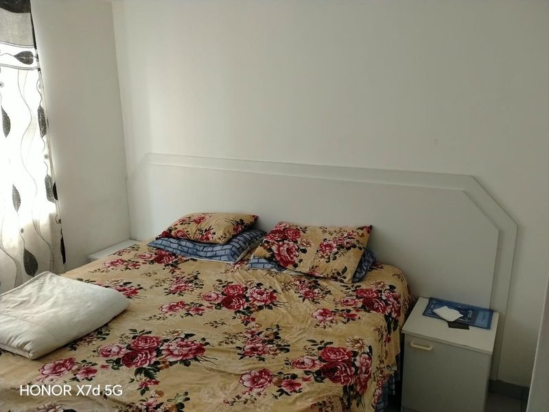 A bedroom featuring a built-in white headboard, providing a neutral foundation for the space.