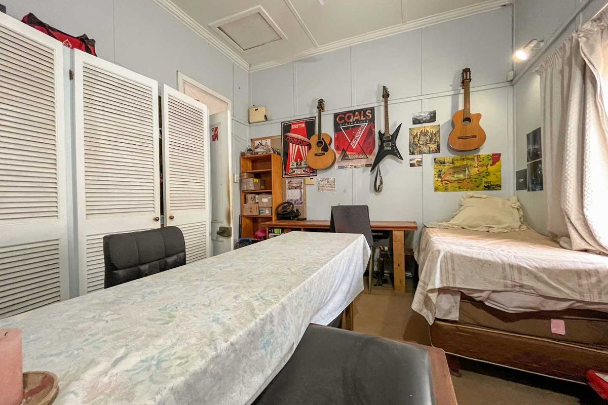 A functional bedroom featuring built-in louvered closet doors and standard ceiling finishes, providing a versatile space for rest or study.