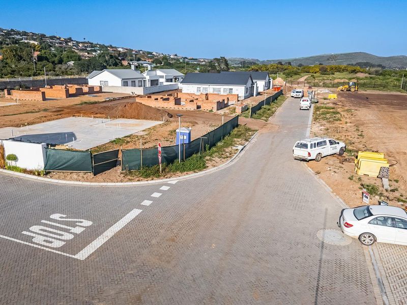 Aerial view of a residential development site showing ongoing construction, paved roads, and building foundations.