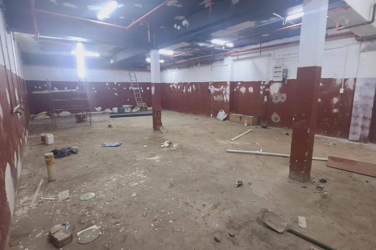 An expansive, unfinished industrial utility space featuring exposed ceiling infrastructure, structural columns, and raw wall finishes, suitable for renovation or storage.
