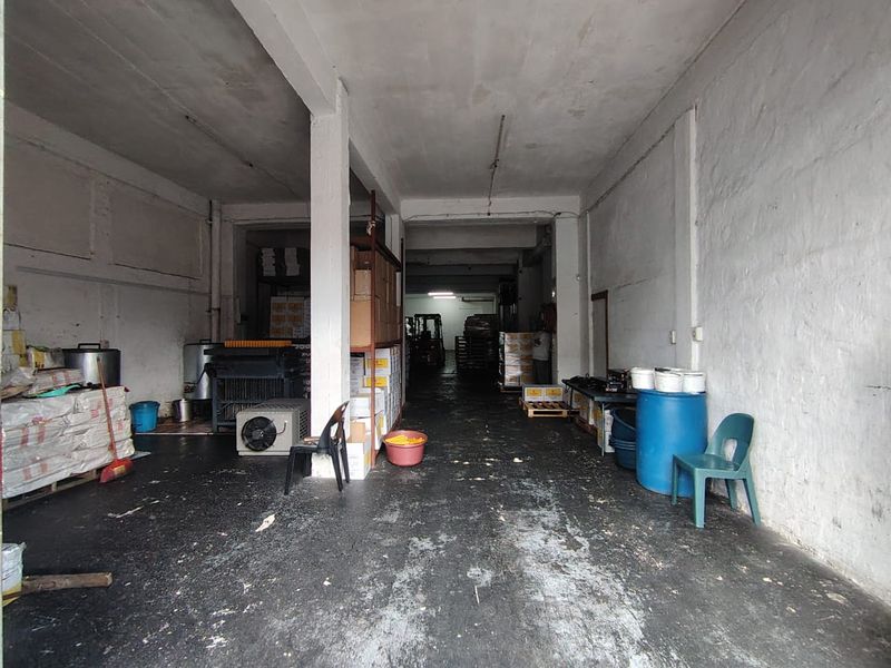 Spacious industrial utility or storage area featuring concrete flooring, structural columns, and painted masonry walls, suitable for warehouse or workshop operations.
