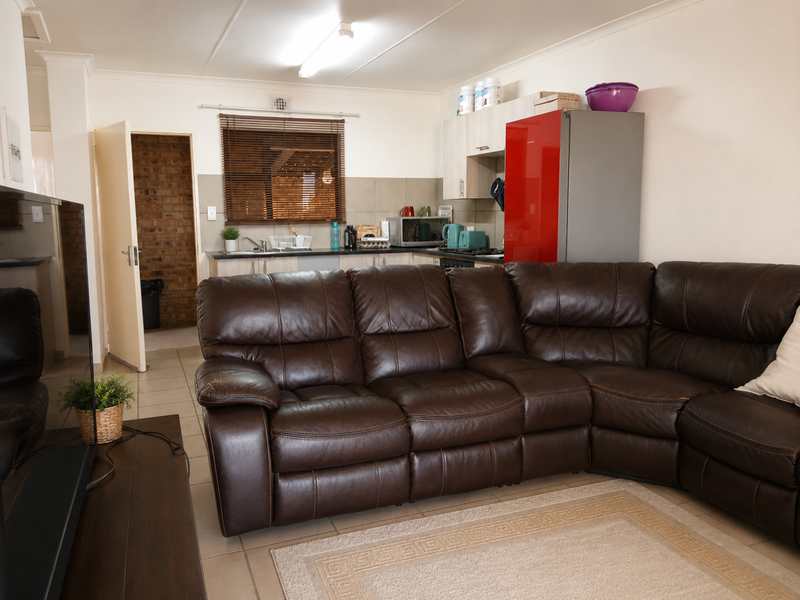 Open-plan living area featuring tiled flooring and an integrated kitchen with built-in cabinetry, providing a functional and connected living space.