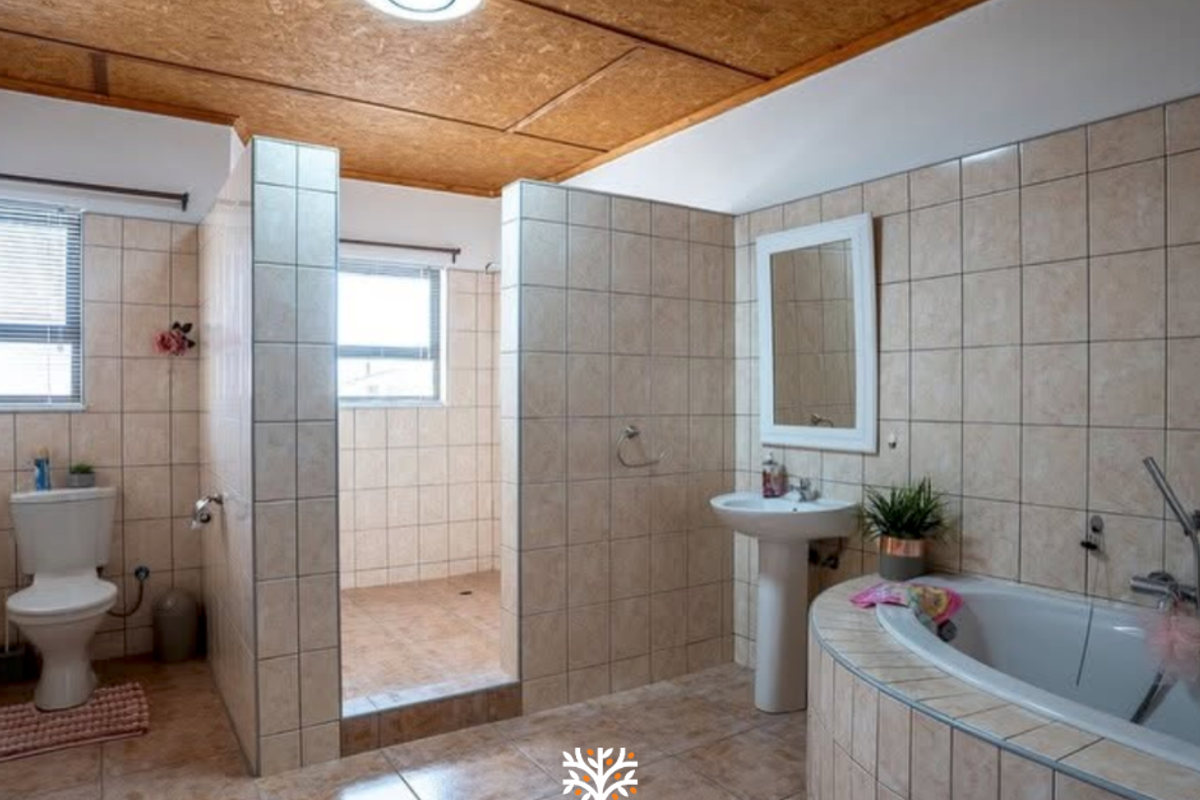 Spacious bathroom featuring a walk-in shower, built-in tiled bathtub, pedestal washbasin, and neutral ceramic tiling throughout.