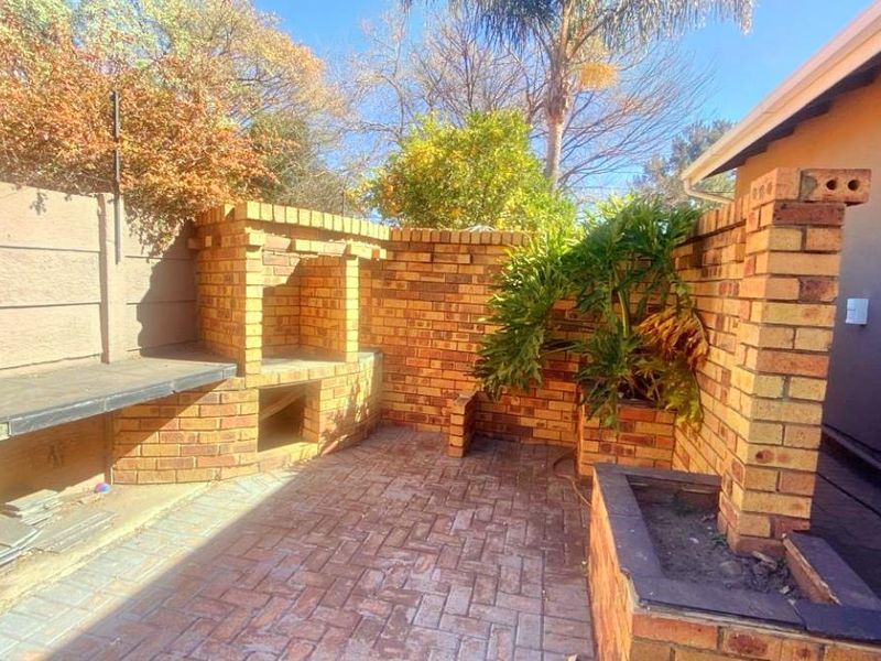 Outdoor patio area featuring a built-in brick braai, brick paving, and integrated brick planter boxes, offering a functional space for outdoor entertaining.