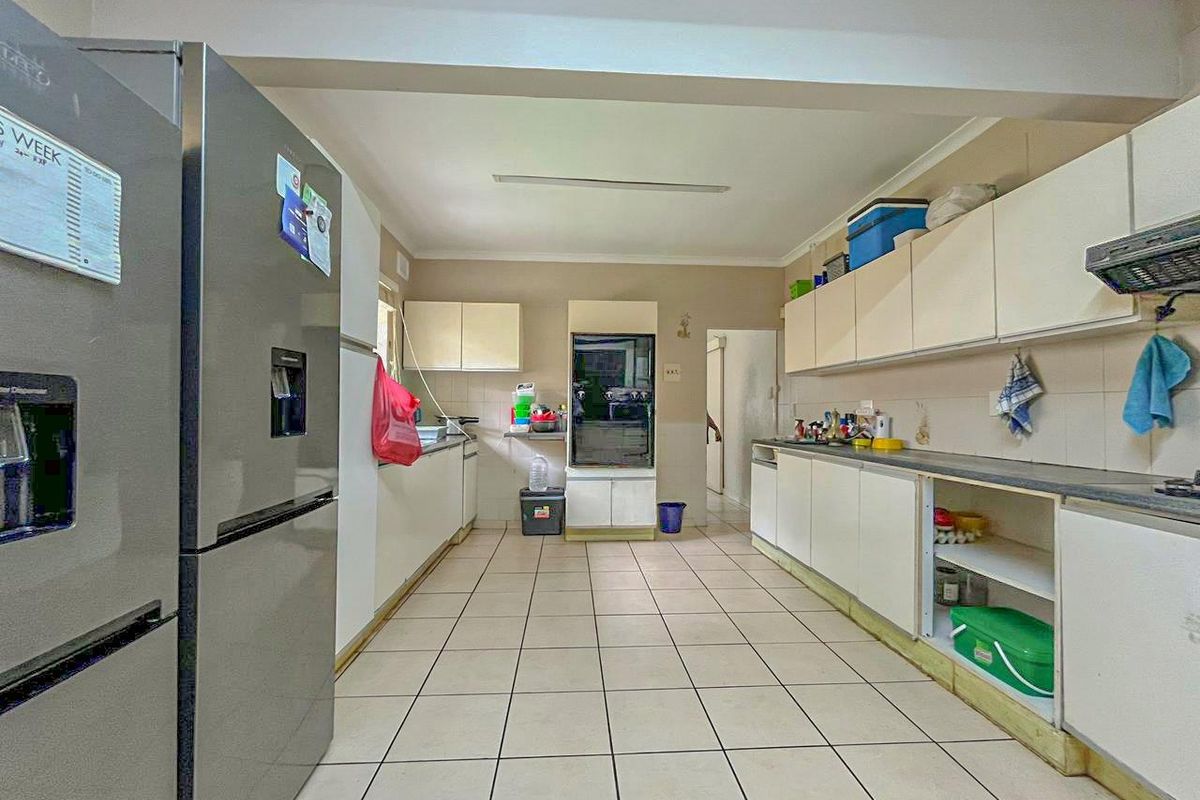 A functional kitchen featuring ample cabinetry, tiled flooring, and a practical layout with integrated appliance space.