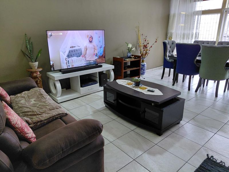 Open plan living and dining area featuring tiled flooring and access to an outdoor space through a sliding glass door.