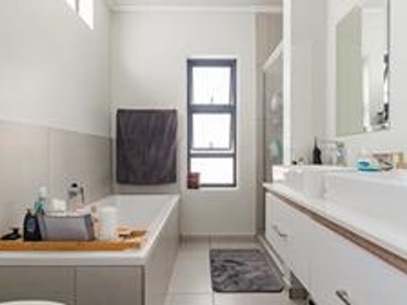 Modern bathroom featuring a double vanity, built-in bathtub, and a separate shower enclosure with clean, contemporary finishes.