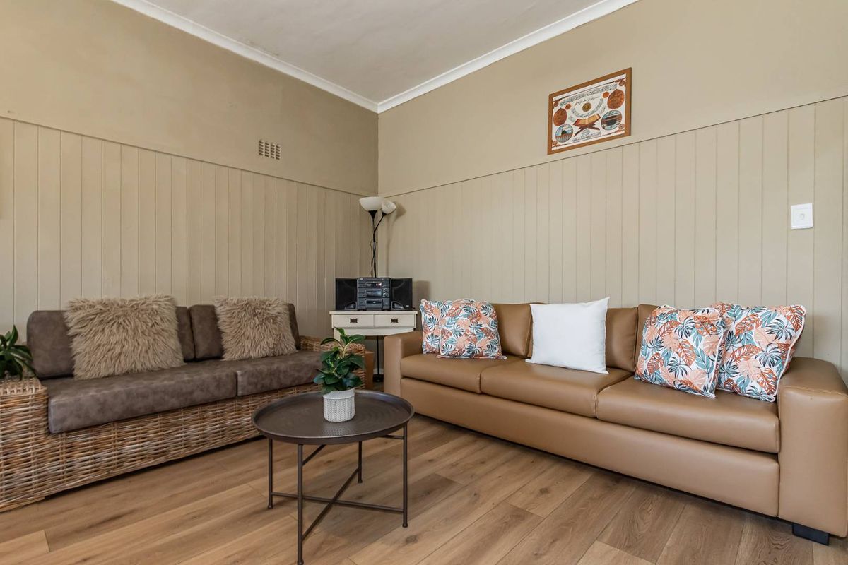 A living room featuring timber-look laminate flooring and vertical wall paneling, providing a neutral base for interior design.
