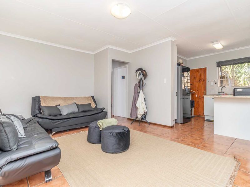 Open-plan living area featuring tiled flooring and a functional kitchen space with a breakfast counter.