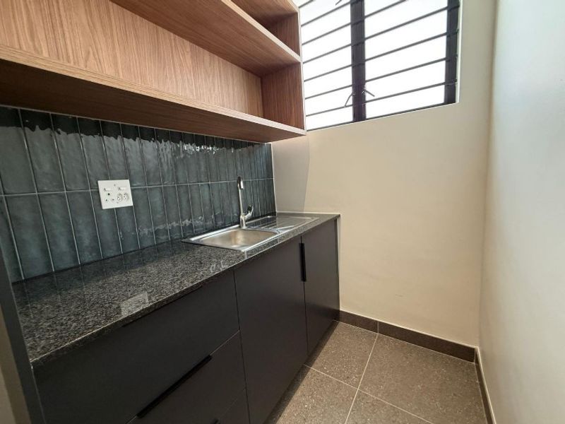 A modern, compact scullery featuring dark cabinetry, granite countertops, a stainless steel sink, and stylish tiled backsplash with open shelving.