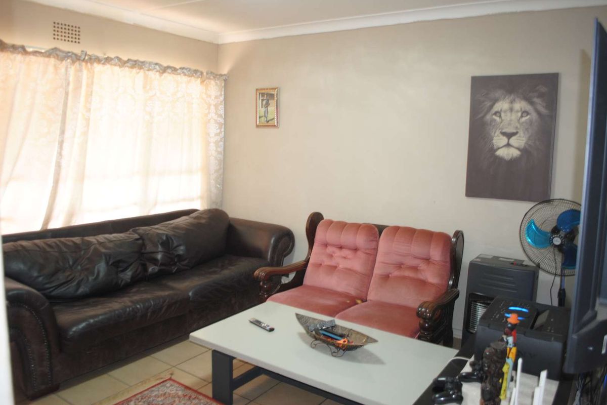 A living room featuring tiled flooring and neutral wall finishes, providing a functional and comfortable space for relaxation.