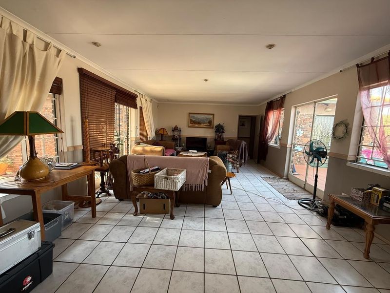 Spacious living room featuring tiled flooring, recessed lighting, and large sliding glass doors that provide ample natural light and access to the exterior.