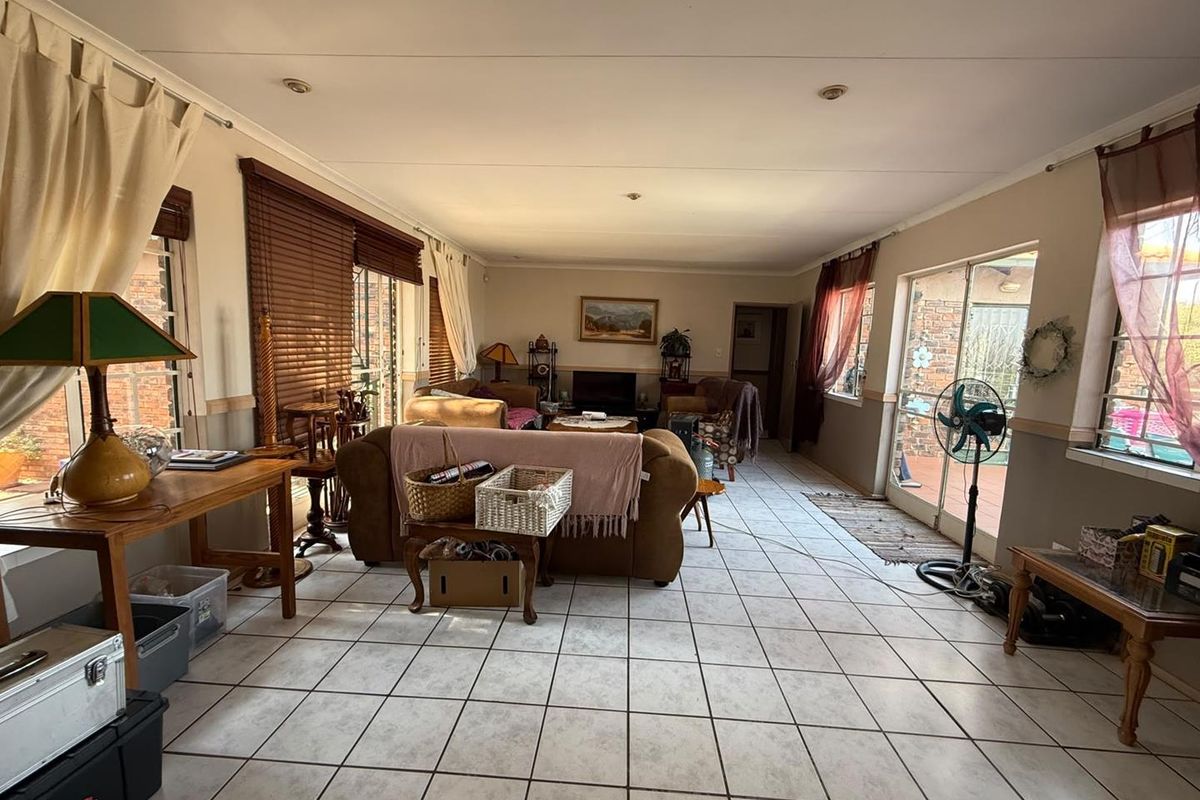 Spacious living room featuring tiled flooring, recessed lighting, and large sliding glass doors that provide ample natural light and access to the exterior.