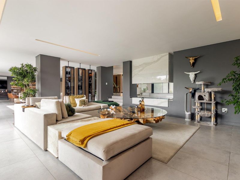 Spacious modern living room featuring large format floor tiles, recessed lighting, and a striking marble-clad built-in fireplace.