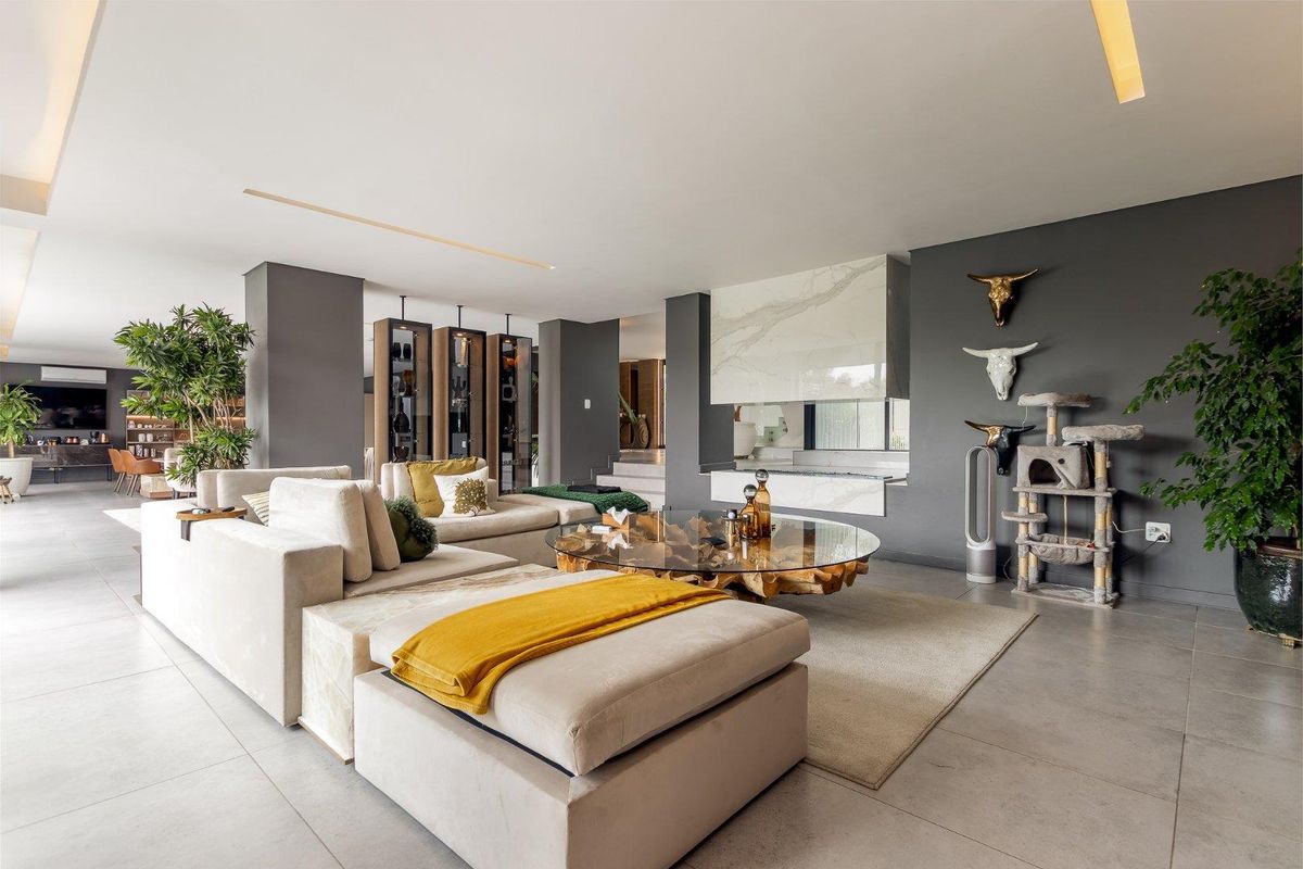 Spacious modern living room featuring large format floor tiles, recessed lighting, and a striking marble-clad built-in fireplace.