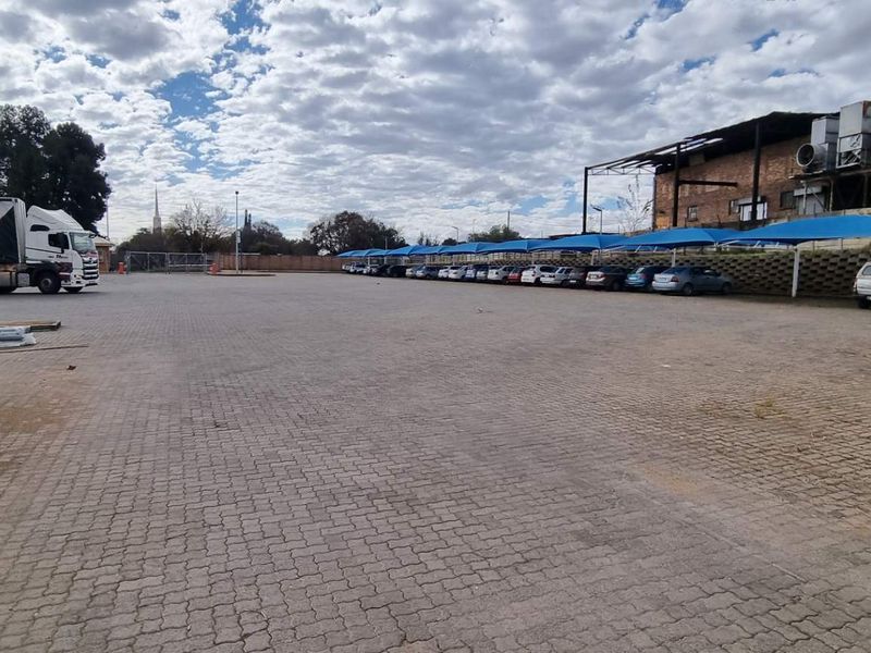 Expansive paved industrial yard featuring covered parking bays and direct access for heavy vehicles.
