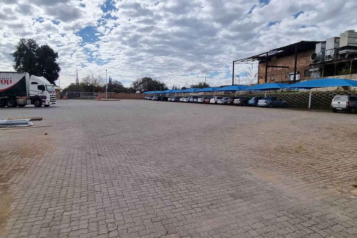 Expansive paved industrial yard featuring covered parking bays and direct access for heavy vehicles.