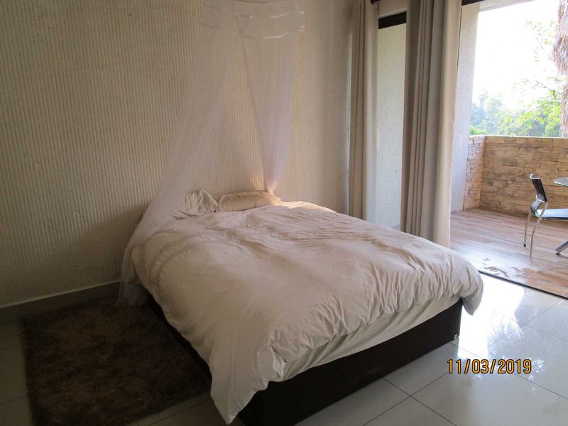 Bedroom featuring tiled flooring and a sliding glass door providing access to an outdoor balcony area.