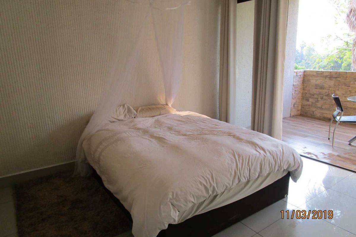 Bedroom featuring tiled flooring and a sliding glass door providing access to an outdoor balcony area.