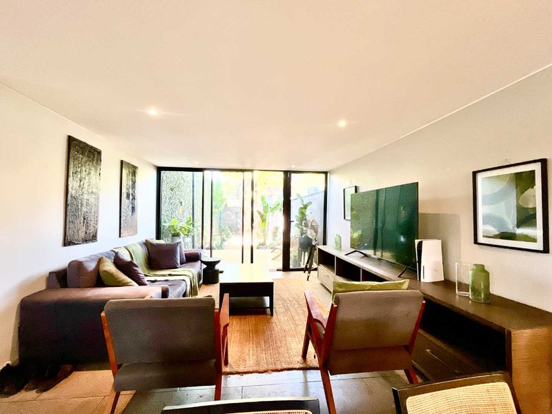 A bright and modern living room featuring large sliding glass doors that provide seamless access to the outdoor area and ample natural light.
