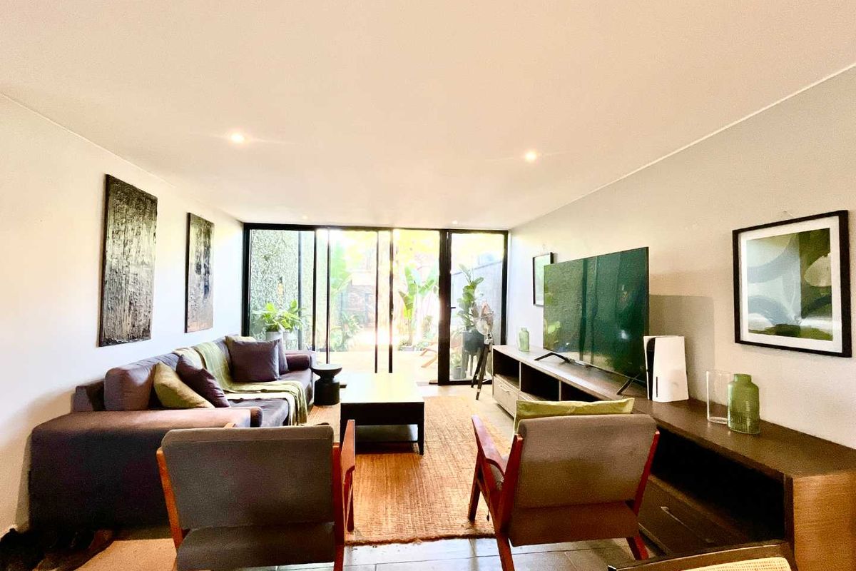 A bright and modern living room featuring large sliding glass doors that provide seamless access to the outdoor area and ample natural light.