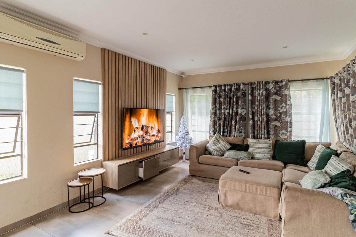 A comfortable living room featuring a modern timber-slat feature wall, built-in cabinetry, and a wall-mounted air conditioning unit.