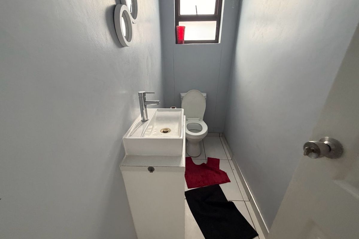 A compact guest bathroom featuring a modern vessel sink vanity and a standard toilet with tiled flooring.