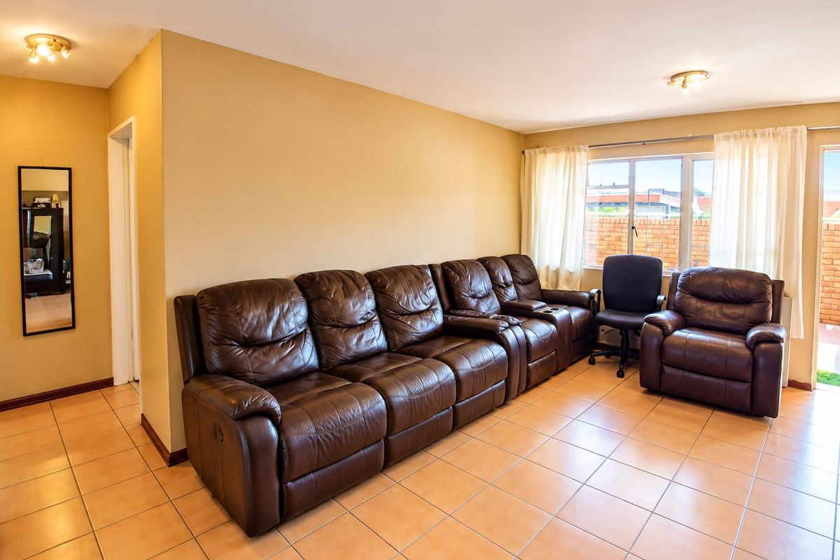 Spacious living room featuring ceramic tile flooring, neutral wall tones, and a sliding glass door providing access to the exterior.