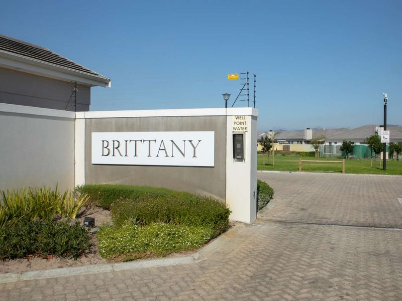 Entrance view of the Brittany estate featuring a paved driveway, security intercom system, and perimeter electric fencing.
