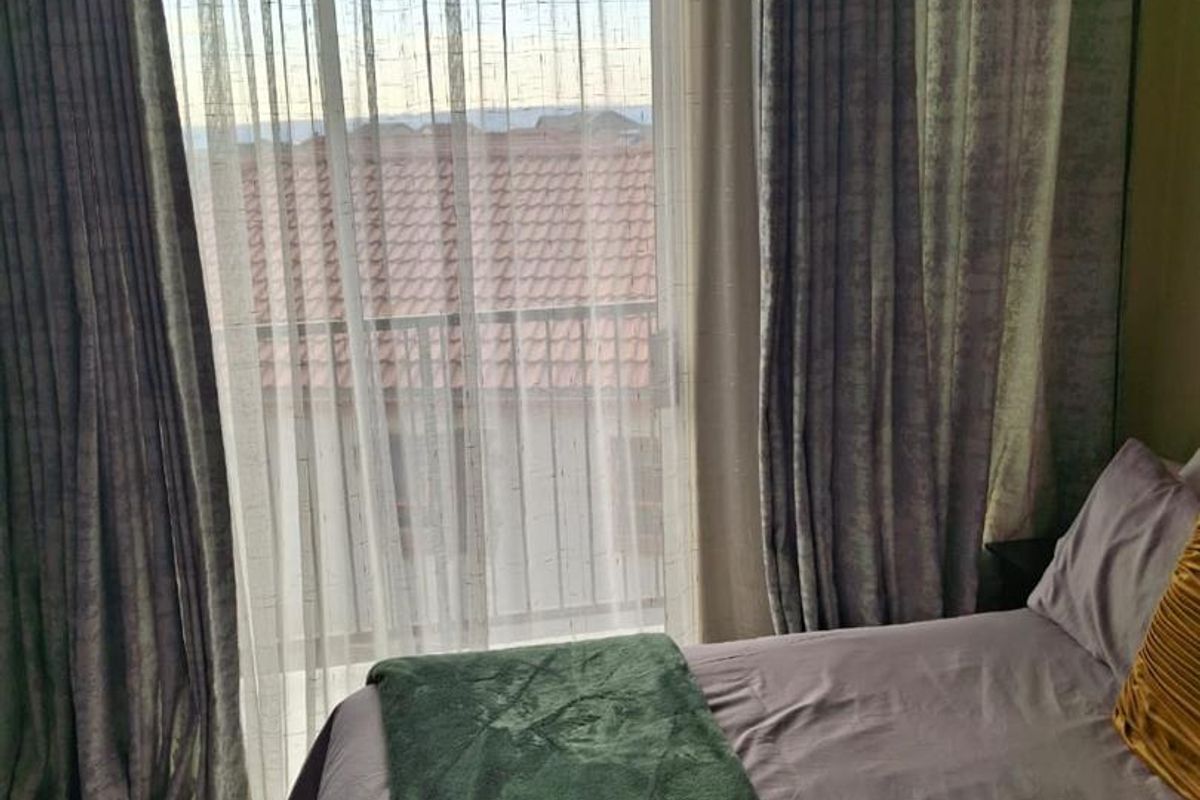 A bedroom featuring tiled flooring and a sliding glass door that provides access to an outdoor area.