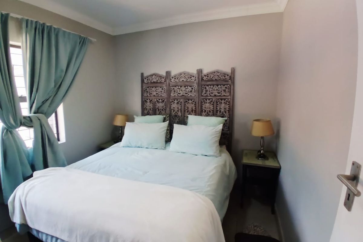 A cozy bedroom featuring neutral wall tones, coving, and a window fitted with security bars, providing a comfortable and functional sleeping space.