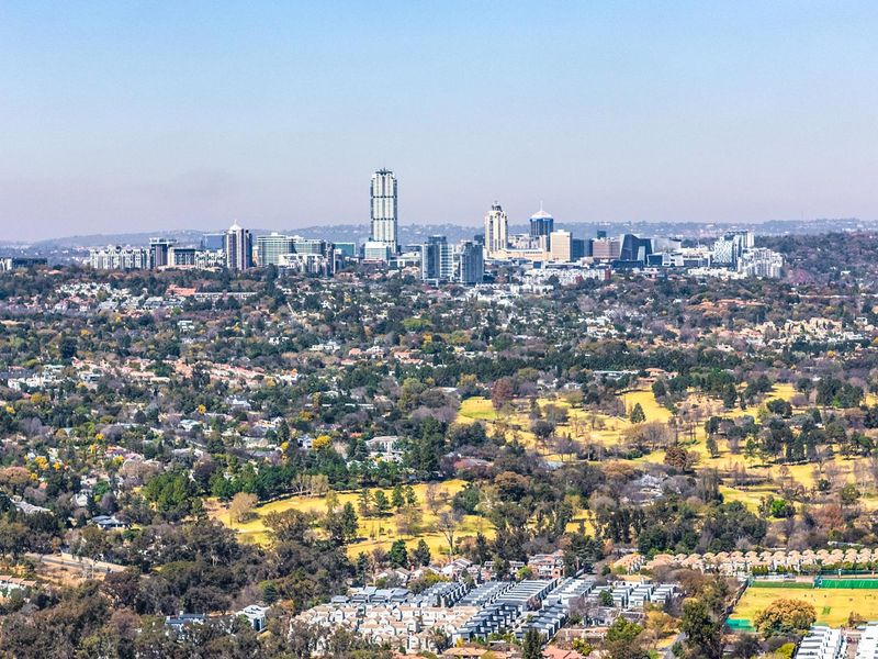 An expansive aerial view showcasing the surrounding landscape, residential areas, and the distant city skyline.