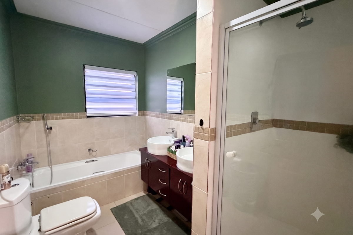 A well-maintained bathroom featuring a built-in bathtub, separate shower enclosure, and a dual vanity with vessel sinks.