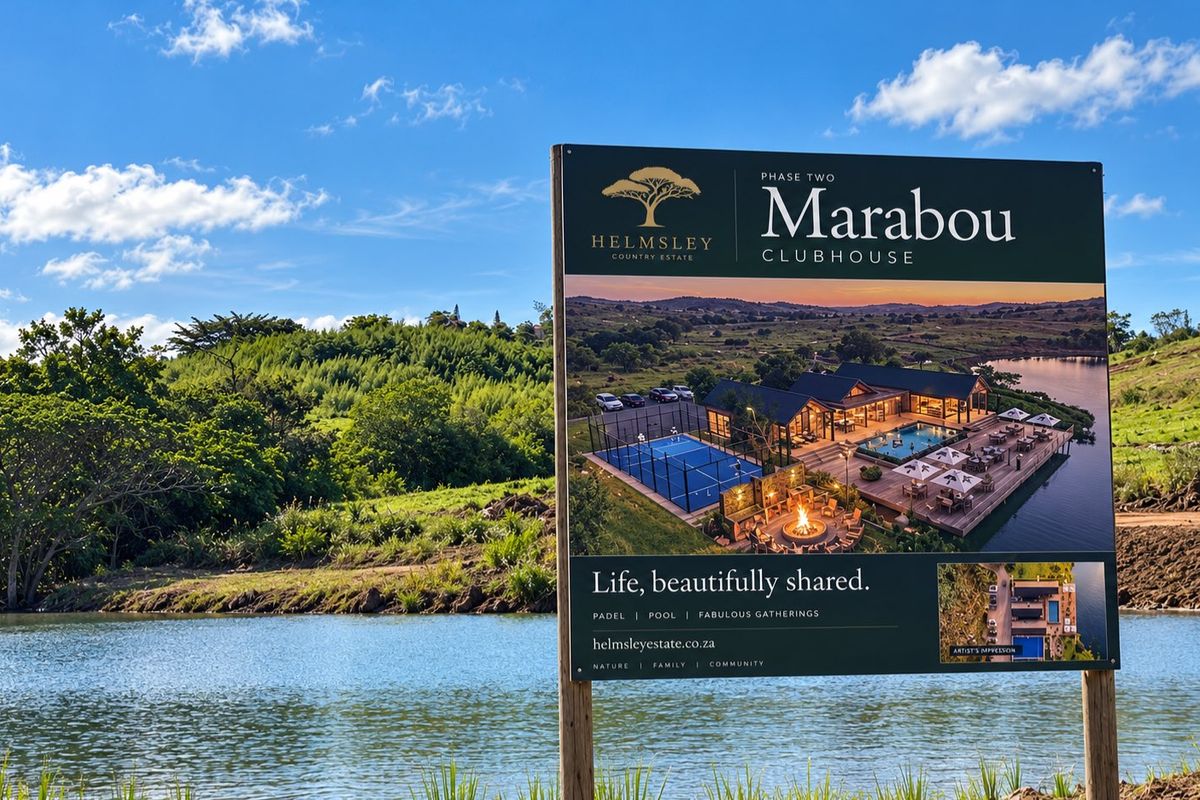 A large promotional billboard showcasing the Marabou Clubhouse development, situated on a scenic vacant land plot overlooking a lake.