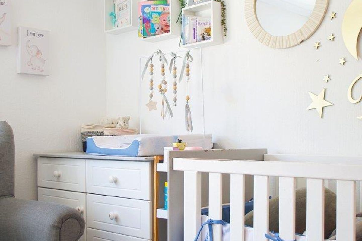 A well-maintained nursery bedroom featuring neutral wall finishes and built-in wall shelving, creating a bright and functional space.