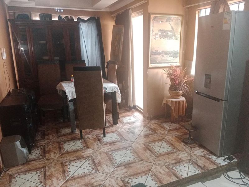 A dining area featuring patterned ceramic floor tiles and crown molding, providing a functional space for meals.