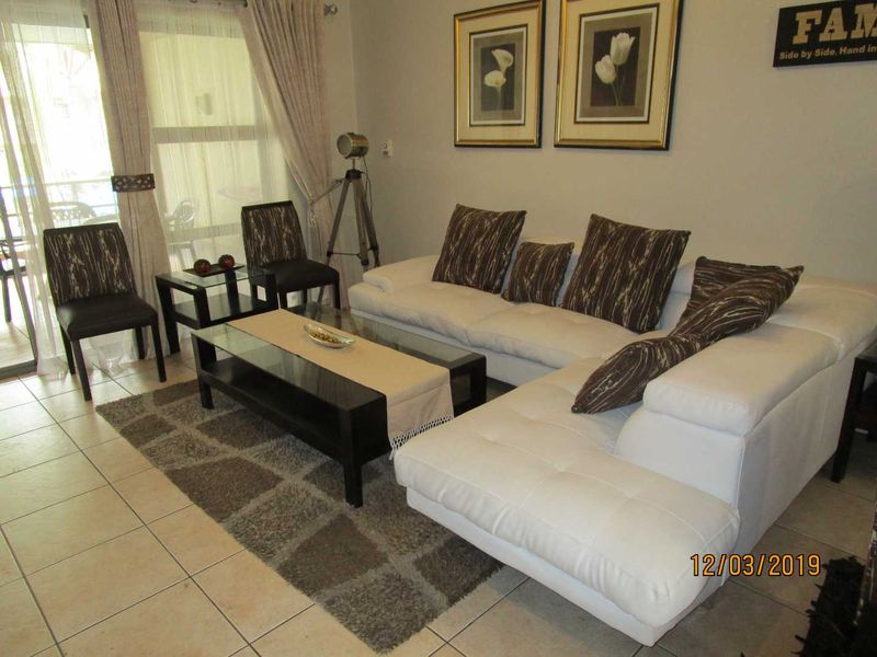A living room area featuring tiled flooring and a sliding glass door providing access to an outdoor space.